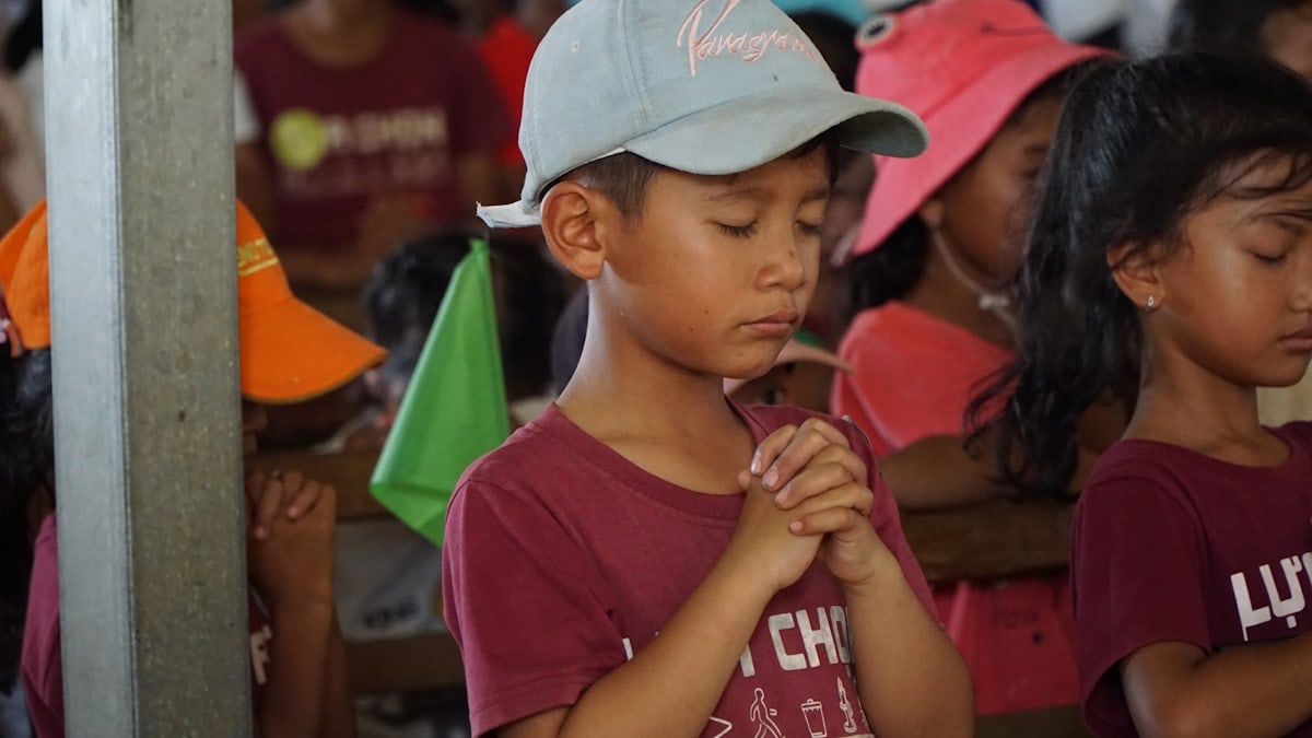 Children are praying with their hands clasped